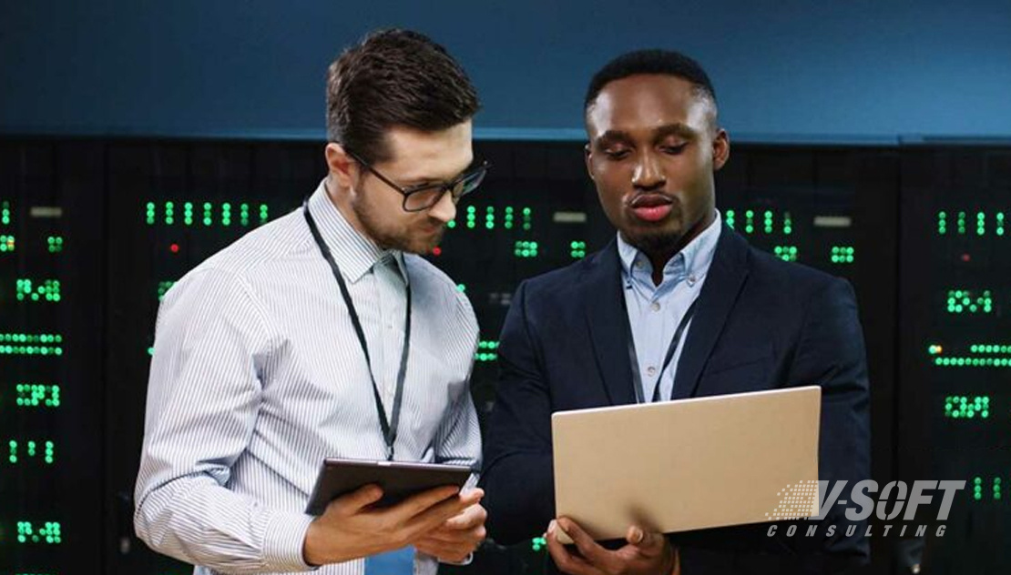 Coworkers using laptop and tablet to discuss data security issues