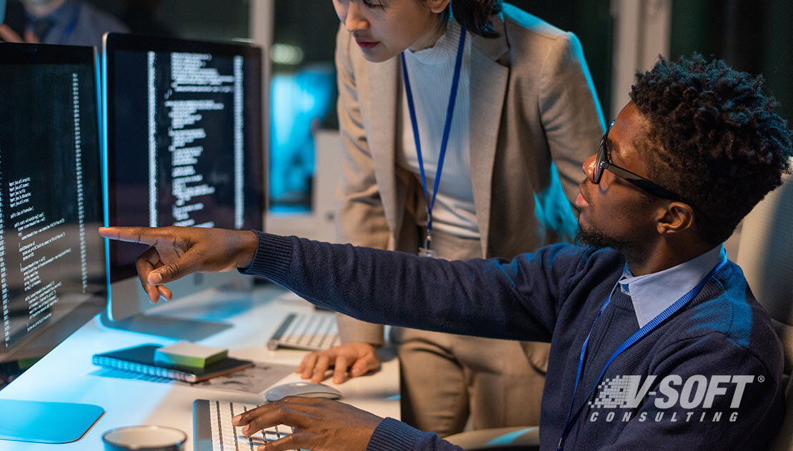 Two ServiceNow professionals working on a desktop computer following security best practices